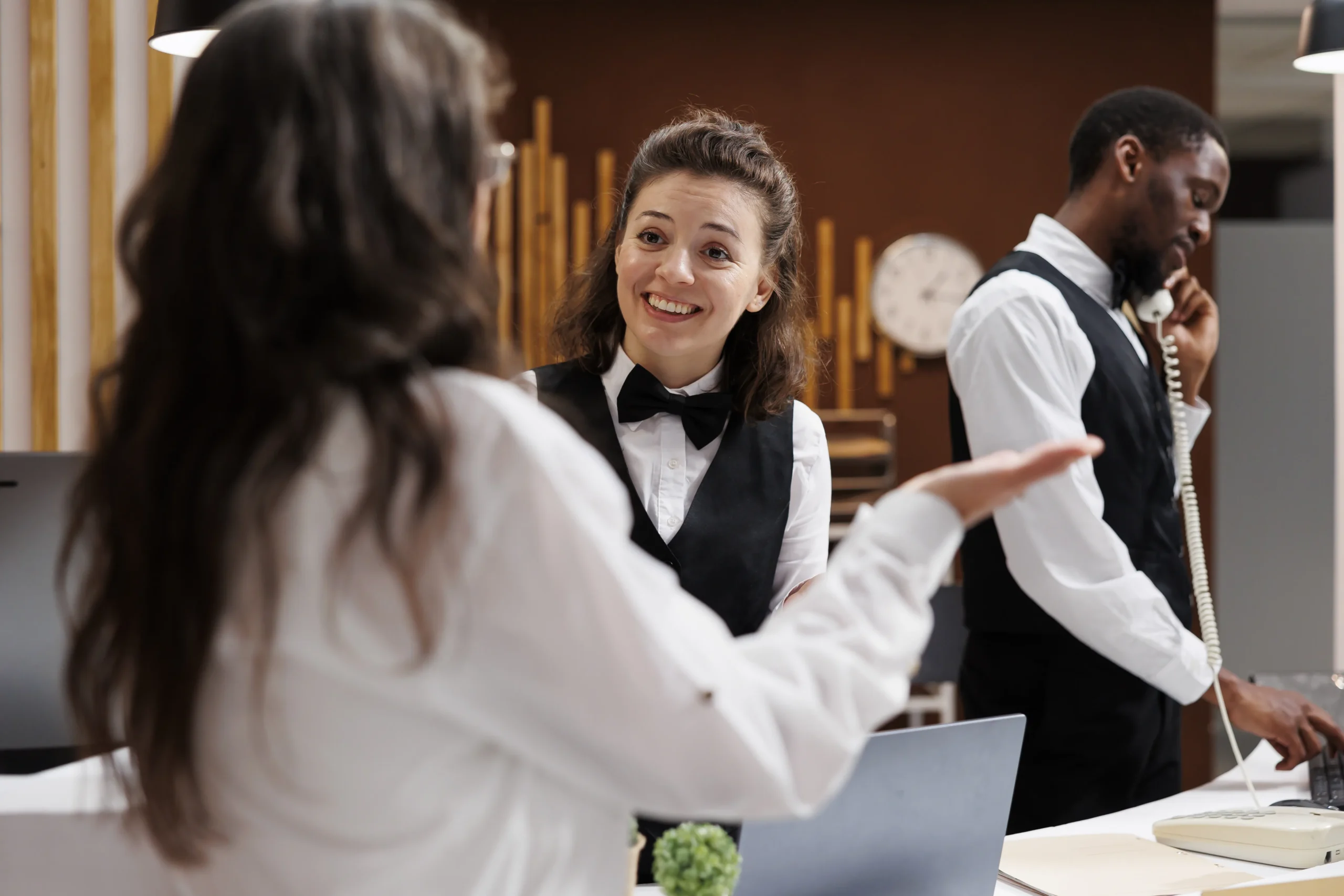 Recepcionista latina atendiendo huésped en hotel de Palm Beach — Team Plus empleos hoteleros Florida